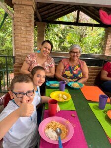 Avó Isabel com sua filha, neto e crianças no refeitório