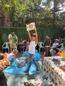 Criança de pé levantado um brinquedo presente pra escola